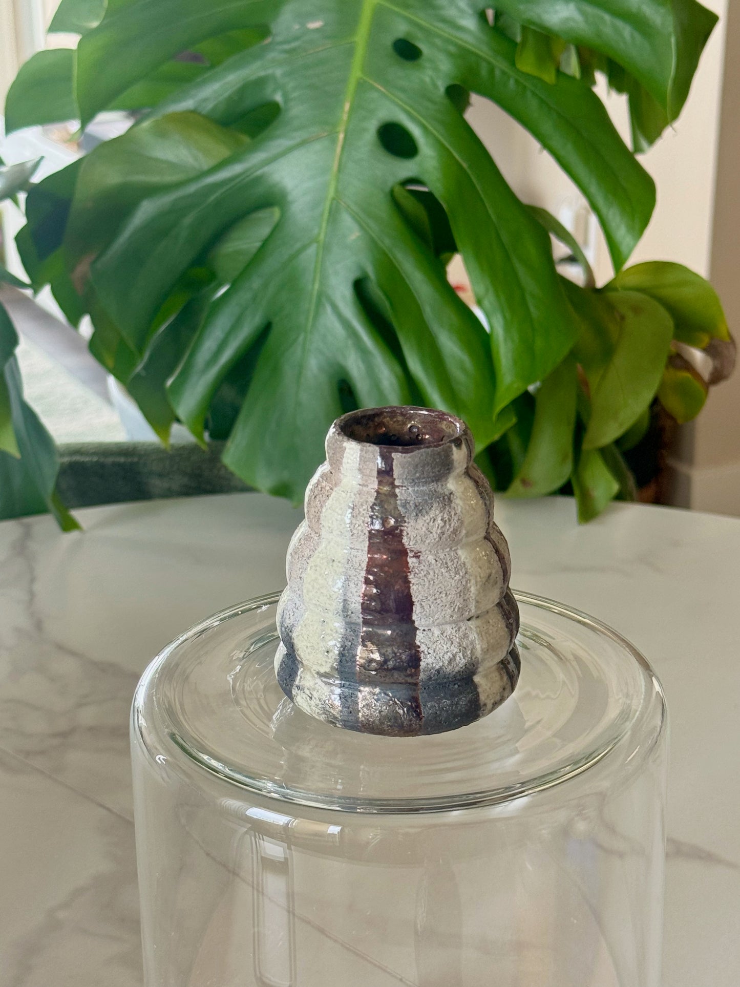 Abstract raku bud vase front view showing iridescent silver-white and plum glaze with ridged form