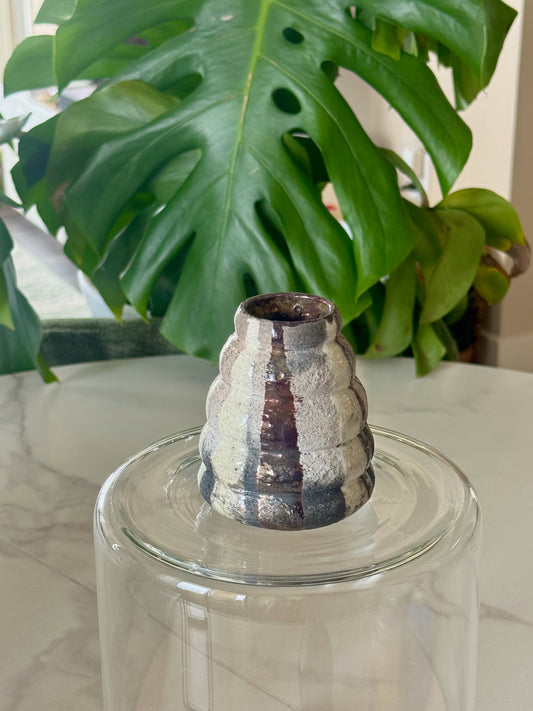 Abstract raku bud vase front view showing iridescent silver-white and plum glaze with ridged form