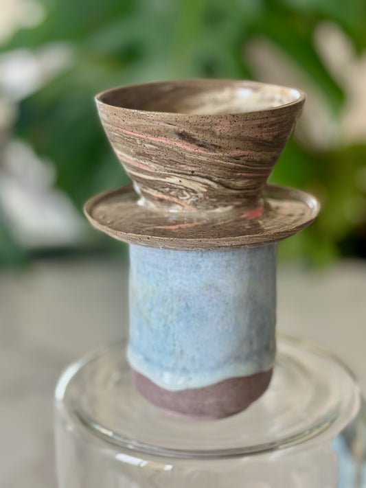 Marbled clay pour-over dripper side view showing flared form and drainage base