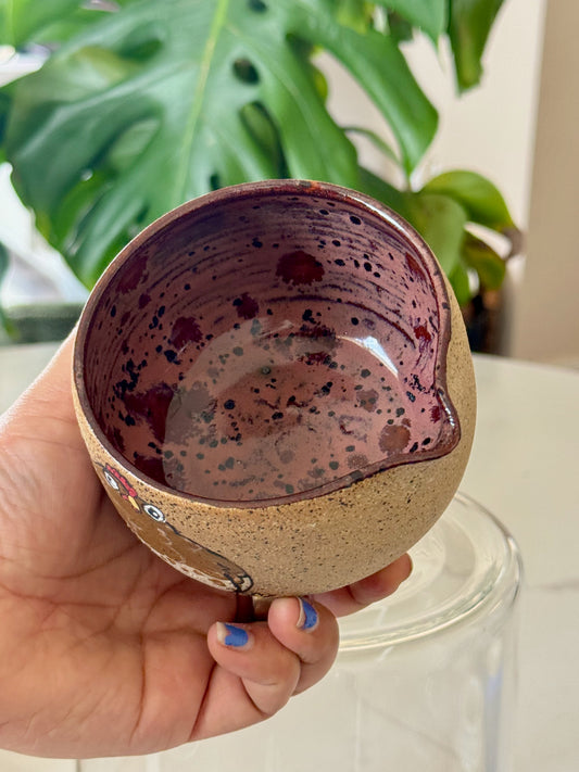 Chicken spouted bowl interior showing deep burgundy speckled glaze