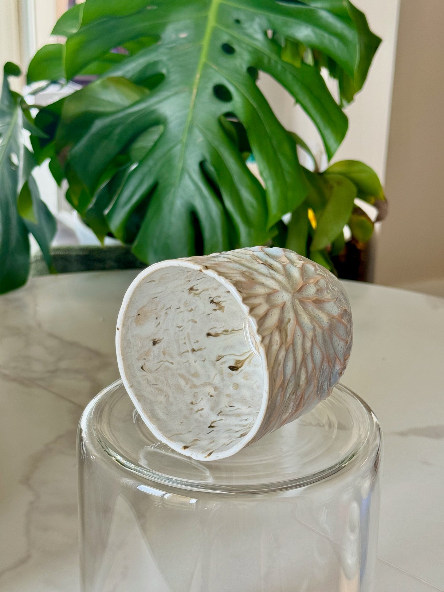 Carved sunflower mug side view showing speckled glaze and carving detail