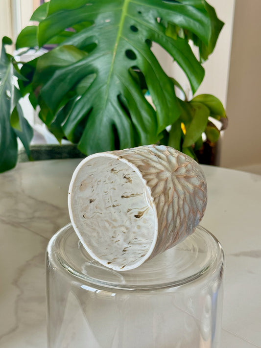 Carved sunflower mug side view showing speckled glaze and carving detail