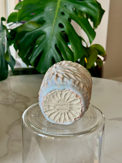 Carved sunflower mug base showing @onlyfrogspottery stamp and carved pattern