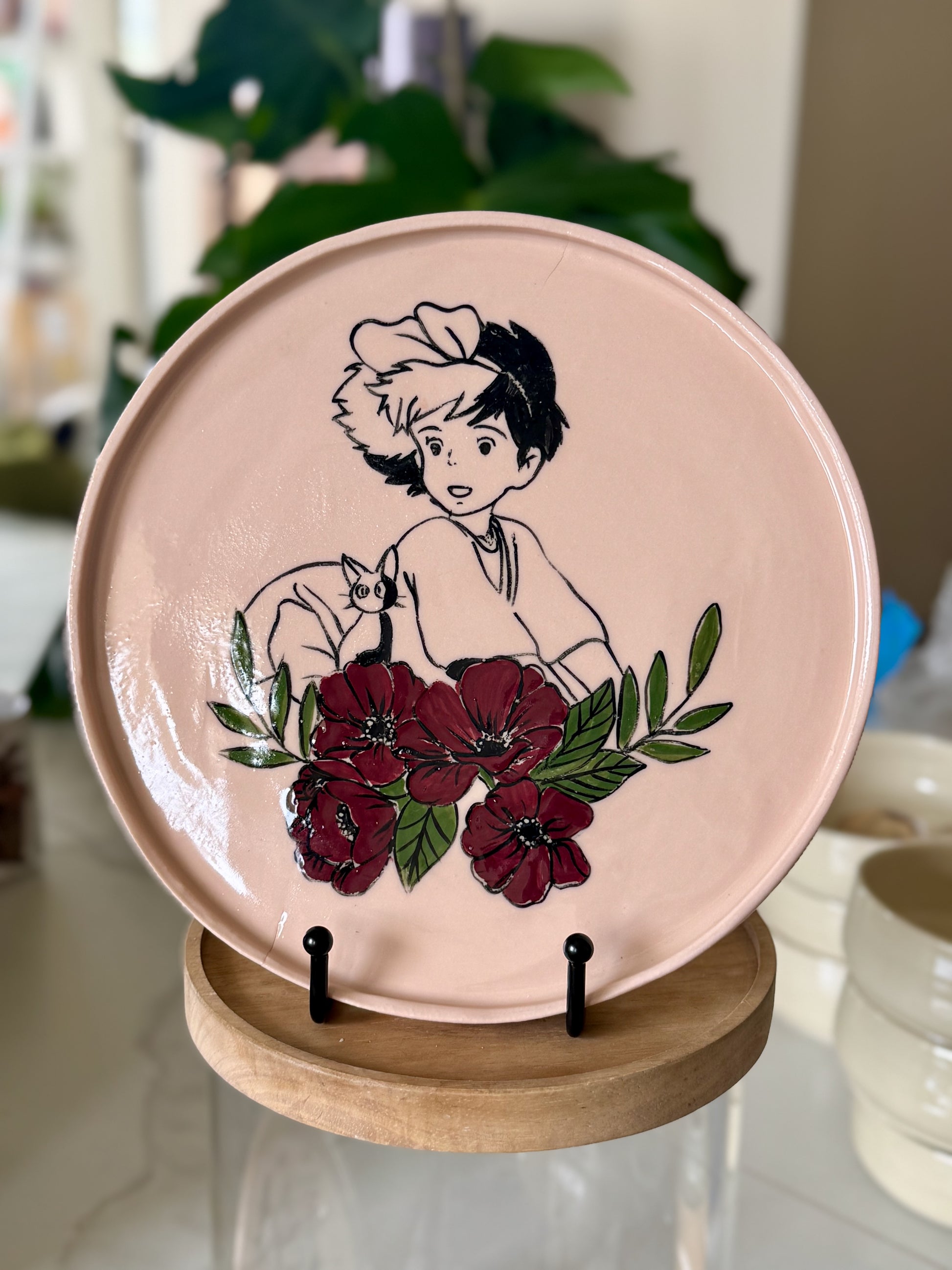 Kiki and Jiji decorative plate with deep red floral border on blush pink glaze