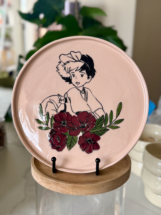 Kiki and Jiji decorative plate with deep red floral border on blush pink glaze