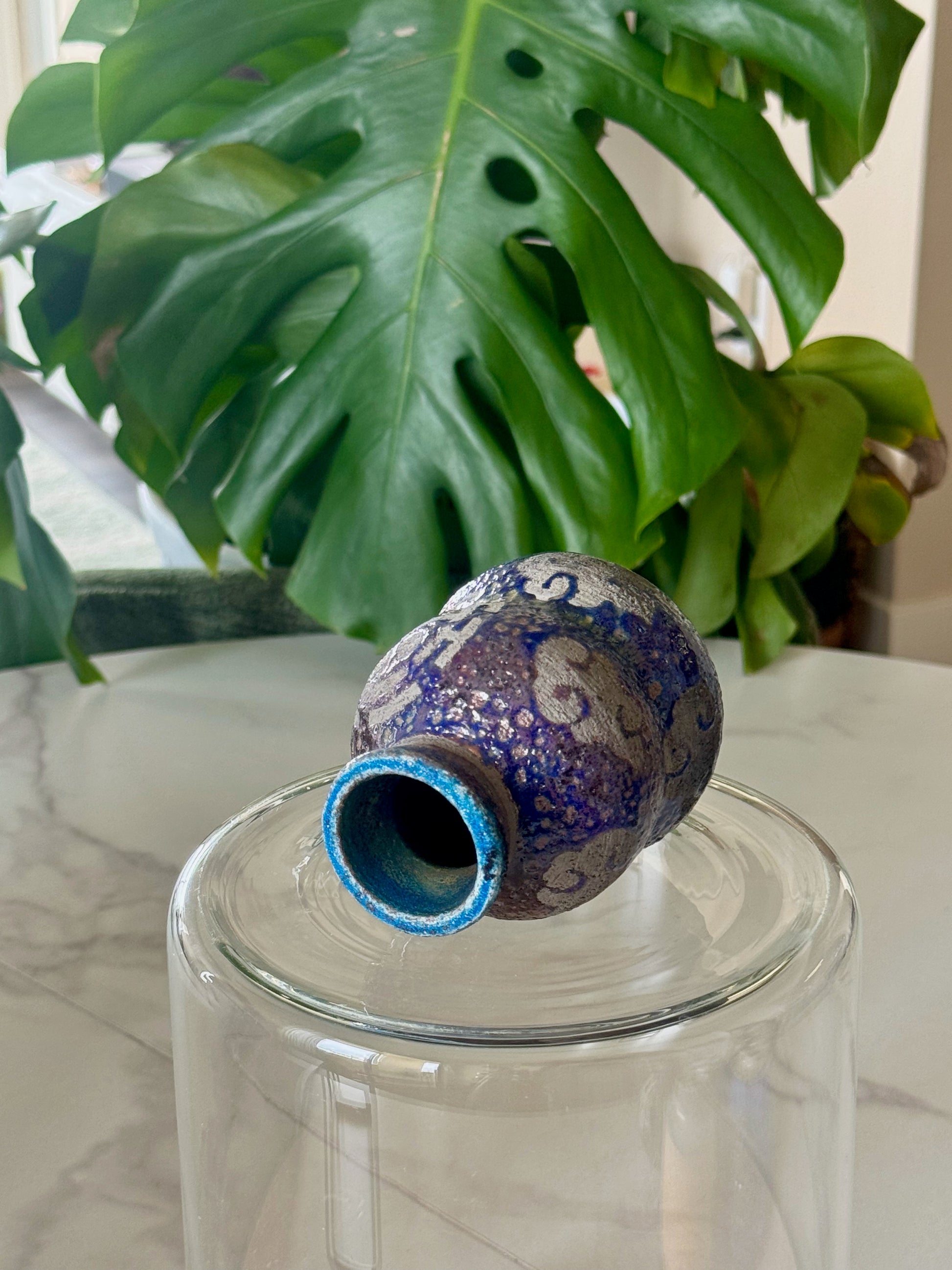 One Piece raku bud vase tilted showing teal interior rim and raku glaze detail