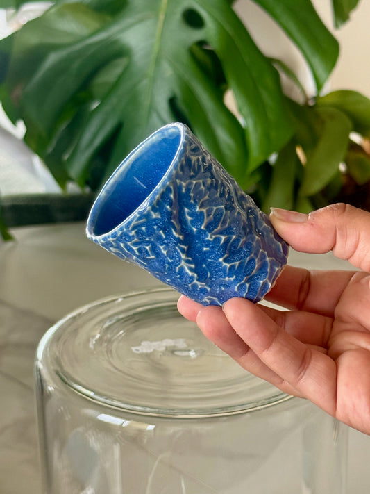 Blue textured glazed shot glass showing deep blue textured surface