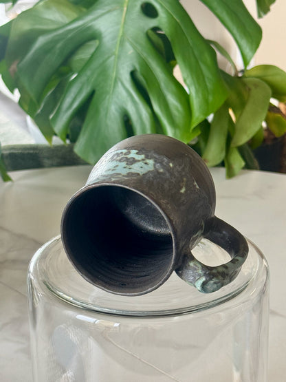 Teal spot glaze mug bottom view showing dark interior and glaze on handle