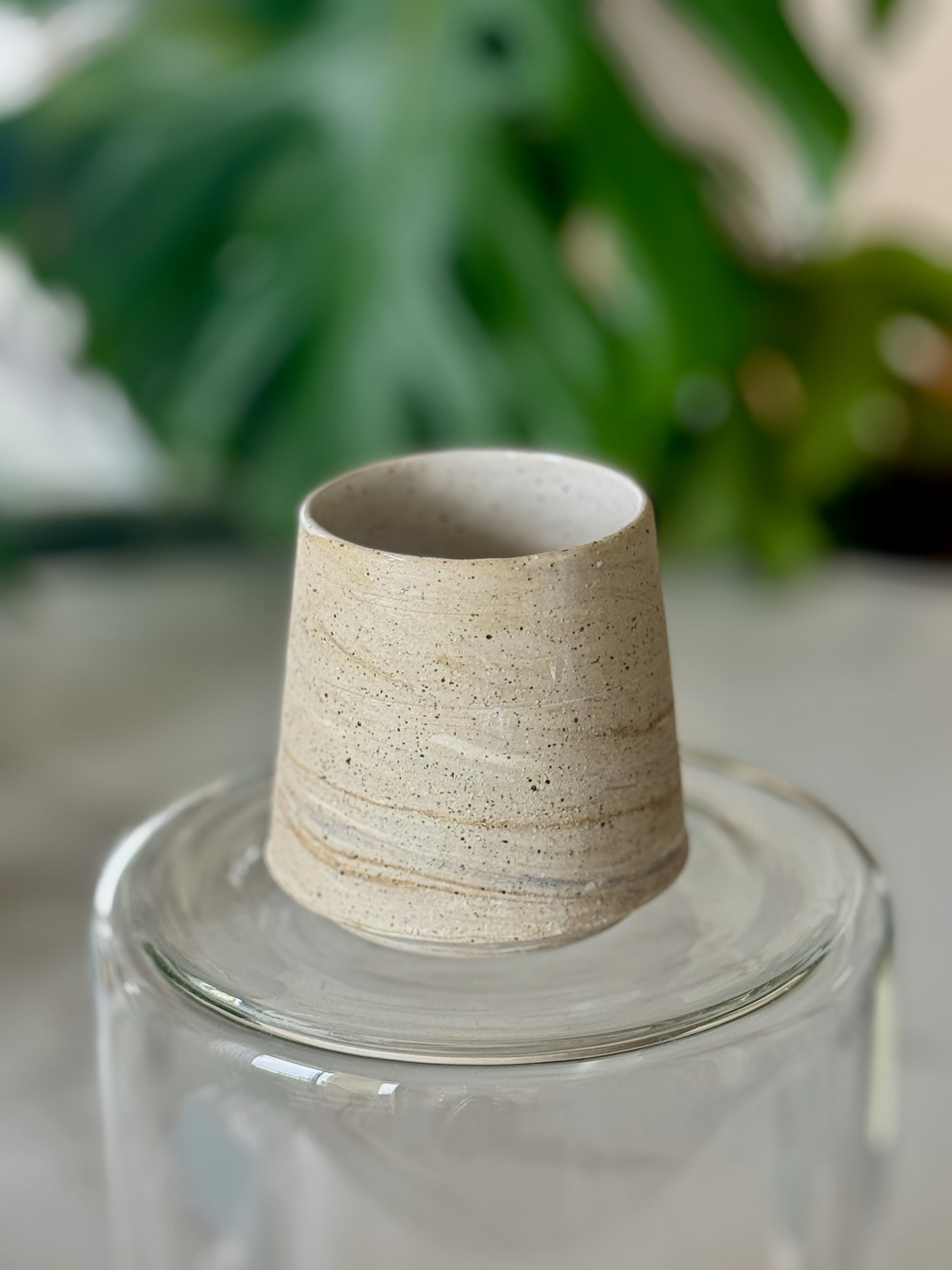 Marbled clay cup showing swirled sandy and cream clay texture with white glazed interior