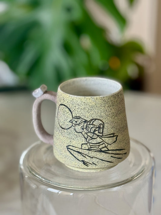 Mandalorian and Grogu Lion King mug front view showing sgraffito illustration on speckled yellow-green clay