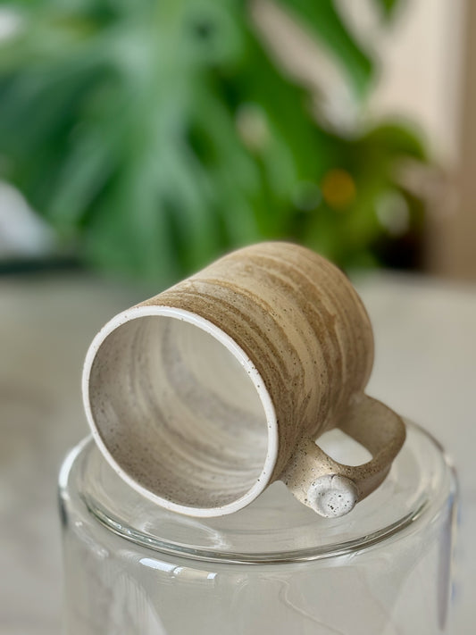 Marbled clay mug bottom view showing white glazed interior and marbled exterior