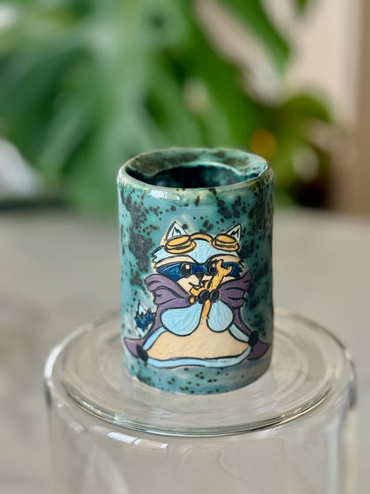 D&D raccoon adventurer cup front view showing illustrated character on speckled teal glaze