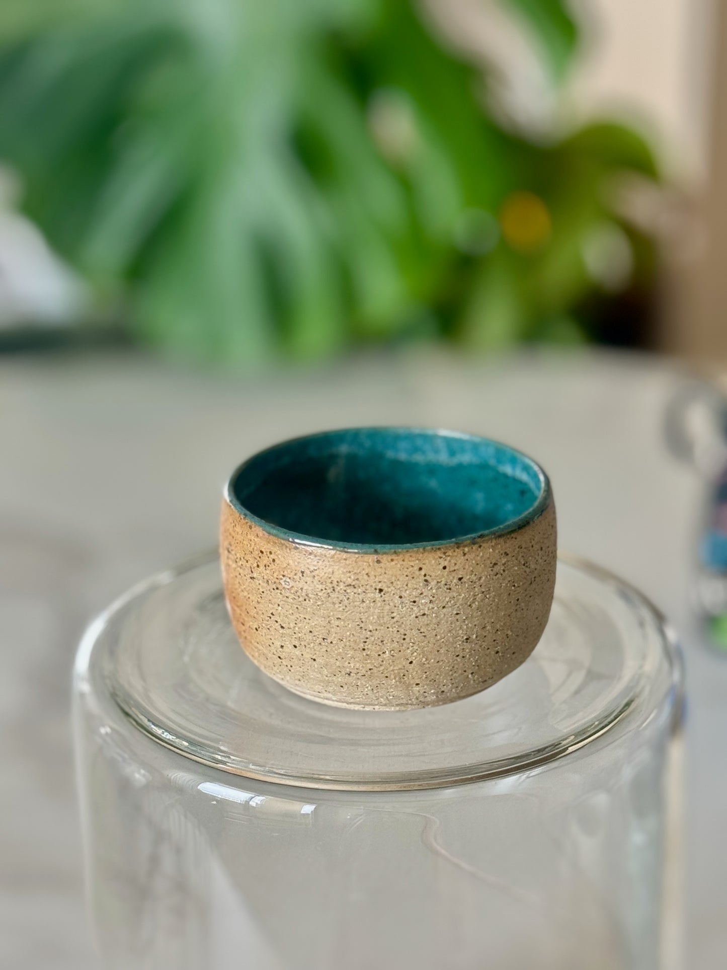 Teal interior catch-all bowl top view showing rich teal glaze inside sandy speckled exterior