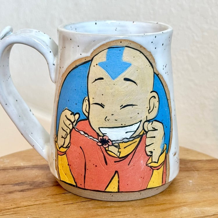 White mug with a cartoon character design on a wooden surface